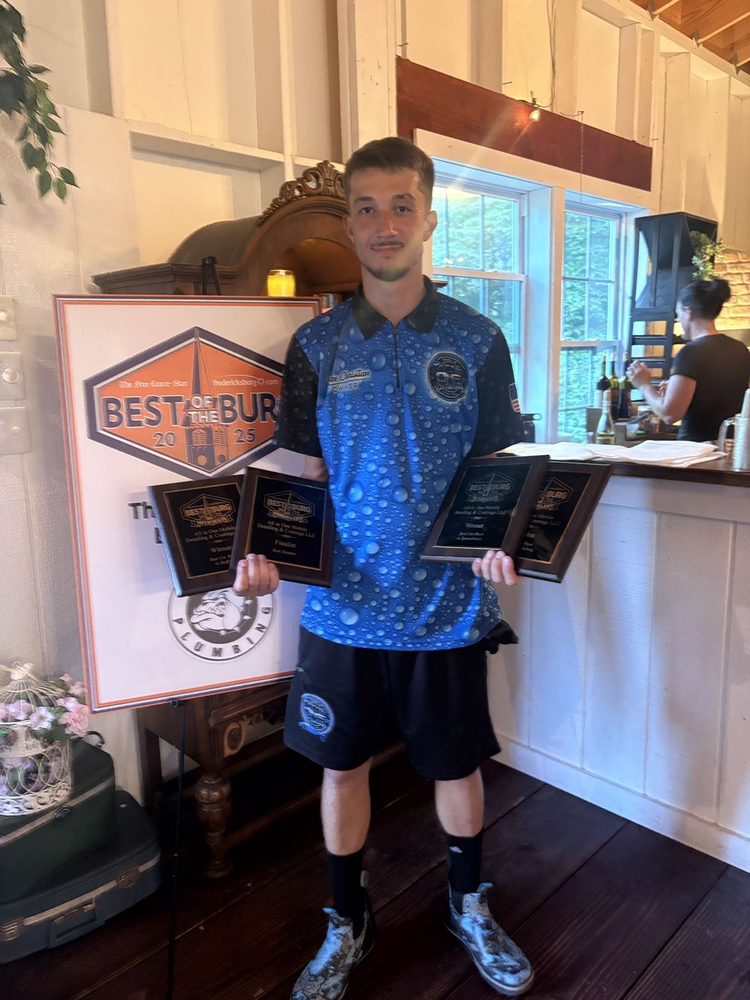 The All-In-One owner holding four Best of the Burg 2025 plaques
